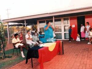 Historical photo: Community gathering featuring the Aboriginal flag displayed on a table during the 1978 Opening of the new BRAMS building in Dora Street.